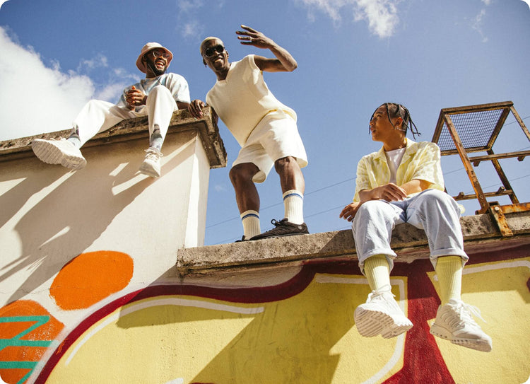 Image of three young men sitting and standing on a wall wearing K-Swiss shoes