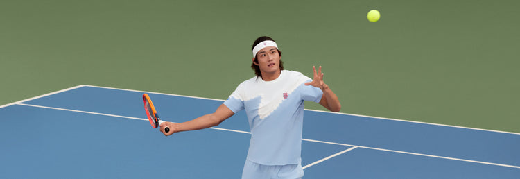 Zhizhen Zhang playing tennis while wearing K-Swiss clothing and a headband