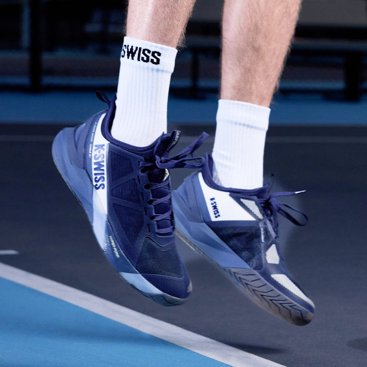 Blue K-Swiss K-Frame tennis shoes on a tennis court