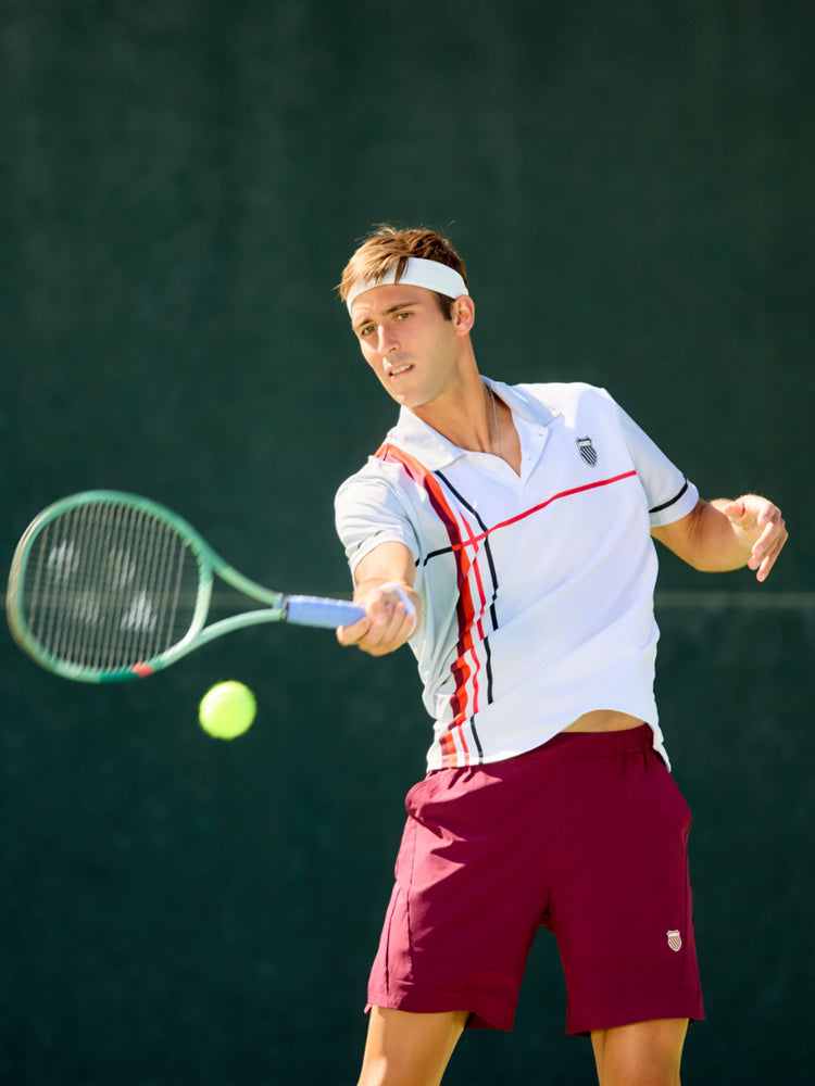 Tomas Etcheverry playing tennis while wearing K-Swiss clothing