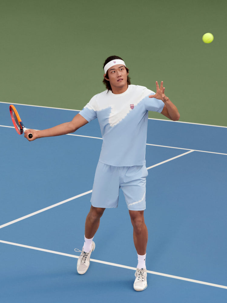 Zhizhen Zhang playing tennis while wearing K-Swiss clothing and a headband