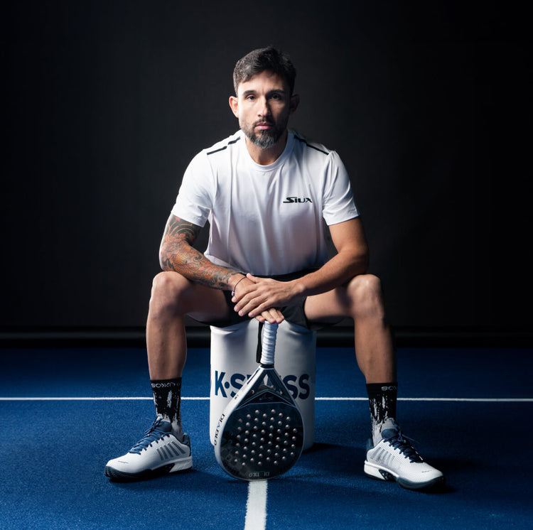 Image of Sanyo Gutierrez sitting on a stool holding a padel racket