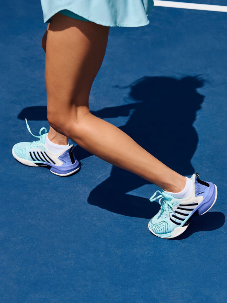 Image of a woman's legs wearing K-Swiss Pickleball Shoes on a blue pickleball court