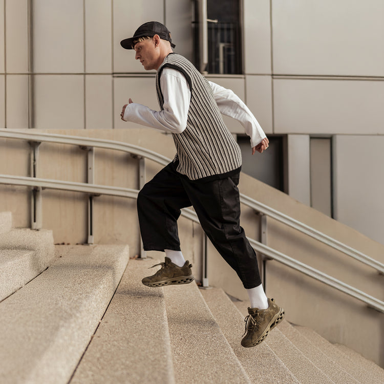 Person running up a set of stairs in an urban setting wearing the K-Swiss Tubes Lite RMX sneakers