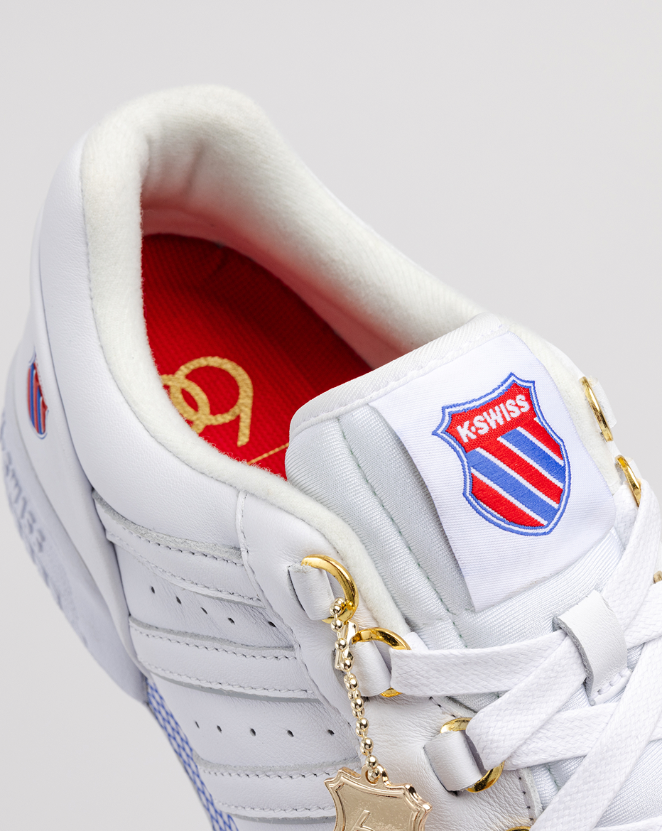 Close up of GSTAAD 60TH white leather sneaker with gold lace charm