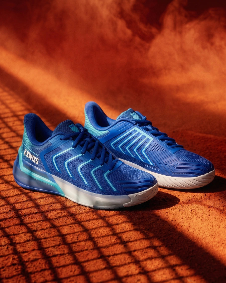 Blue running shoes with white soles on a textured orange surface