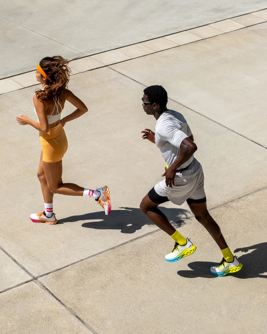 Two people running on a concrete surface