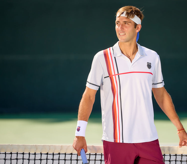 Man on a tennis court wearing K-Swiss clothing and accessories