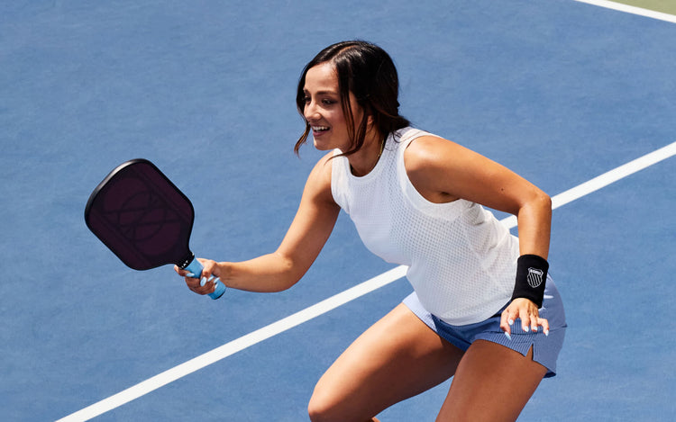 Image of a woman on a pickleball court wearing K-Swiss apparel and wrist band