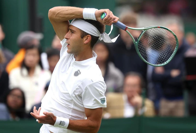 Tomas Etcheverry holding a tennis racket at a tennis match while wearing K-Swiss clothing