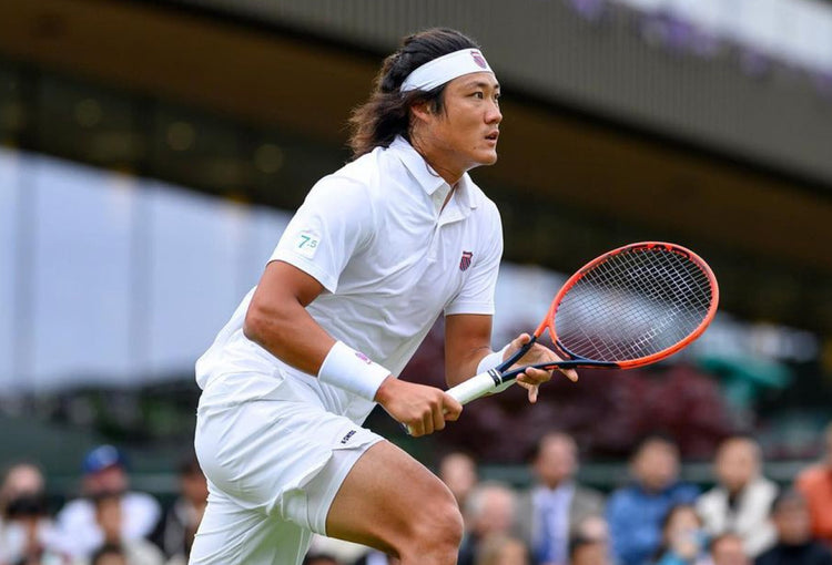 Zhizhen Zhang playing tennis while wearing K-Swiss clothing and accessories