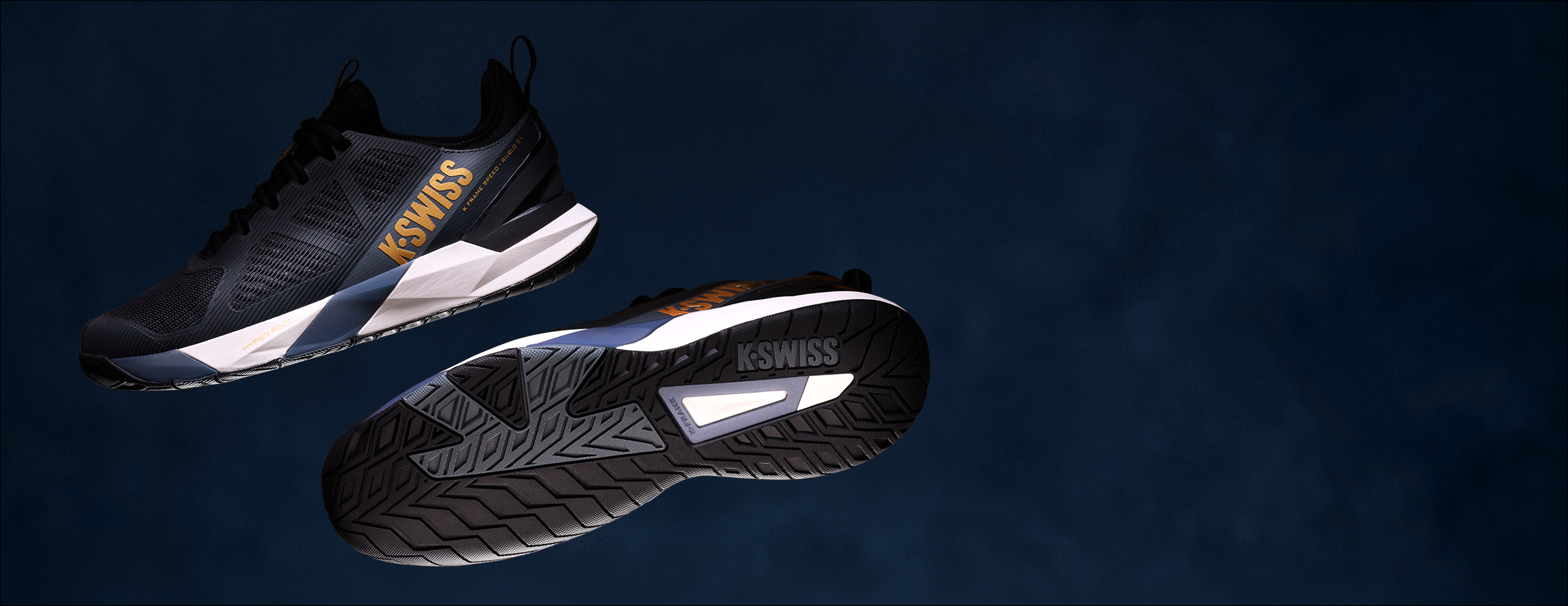 A pair of K-Swiss athletic sneakers shown floating against a dark blue textured background, displaying both the side profile and the sole of the shoes.