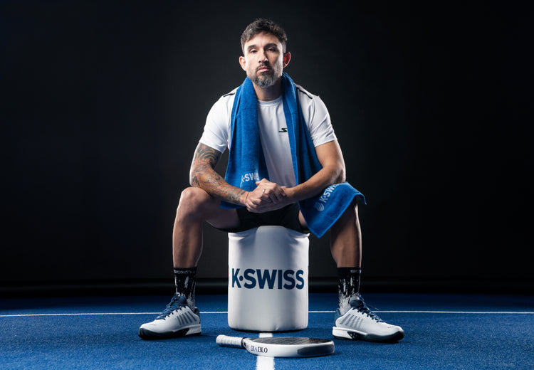 Sanyo Gutierrez sitting on a K-Swiss stool and wearing K-Swiss padel shoes