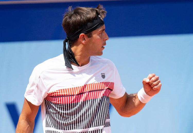 Tomas Etcheverry holding up a fist in celebration at a tennis tournament while wearing K-Swiss clothing