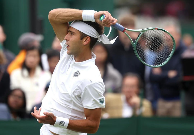 Tomas Etcheverry holding a tennis racket at a tennis match while wearing K-Swiss clothing