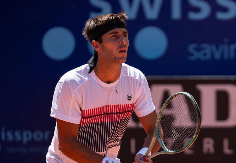 Tomas Etcheverry playing tennis while wearing K-Swiss clothing