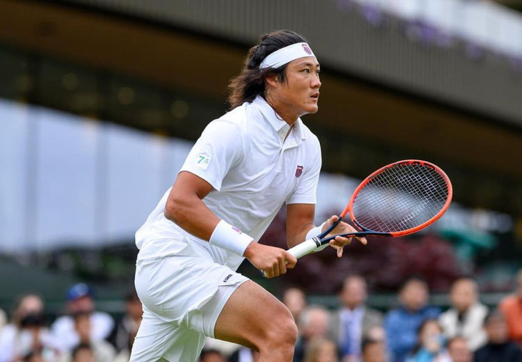 Zhizhen Zhang playing tennis while wearing K-Swiss clothing and accessories