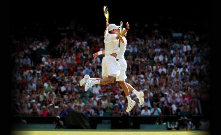 Image of two tennis players jumping and celebrating during a tennis match while wearing K-Swiss tennis shoes