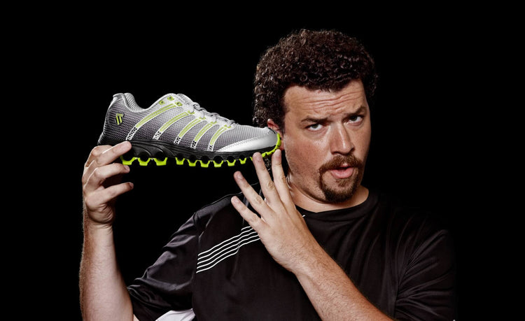 Image of a man holding K-Swiss Tubes shoes